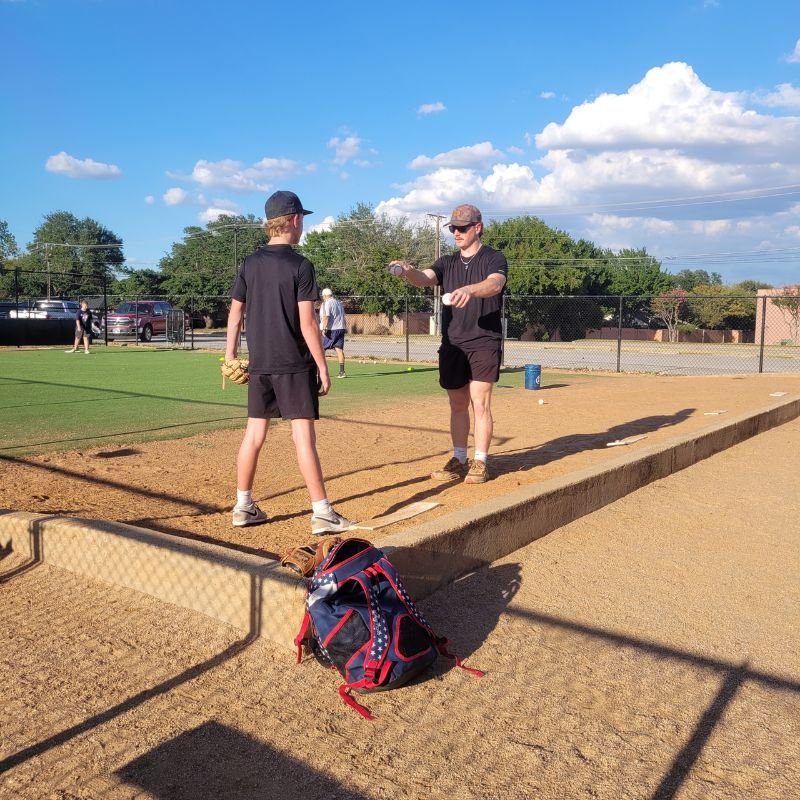 Mason Hamilton coaching a youth baseball player in North Richland Hills, Texas